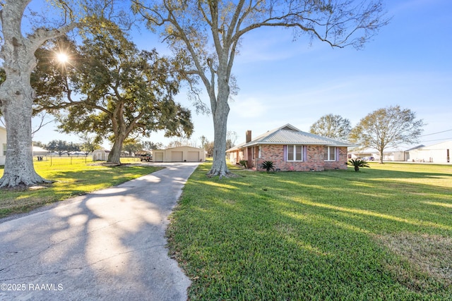 ranch-style home with a garage, an outbuilding, and a front lawn