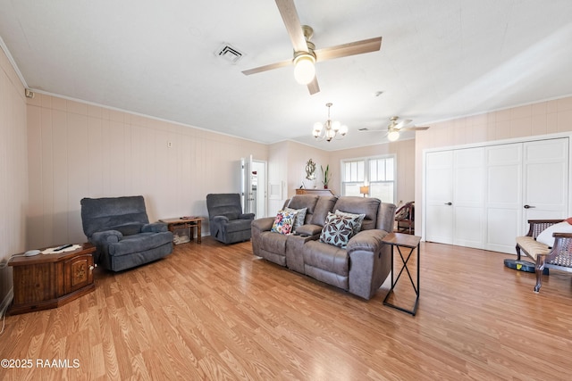 living room with ornamental molding, ceiling fan with notable chandelier, and light hardwood / wood-style flooring