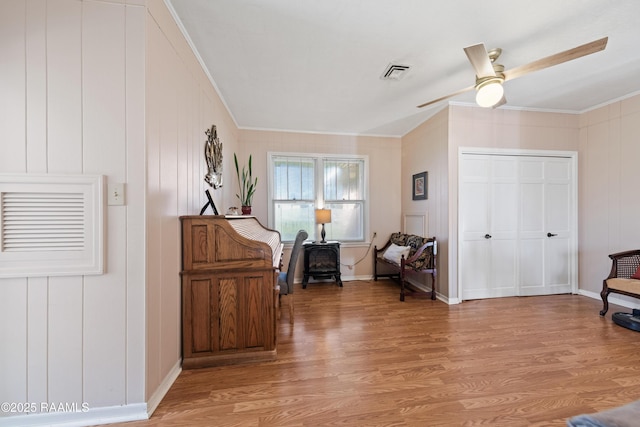 sitting room with crown molding, ceiling fan, and light hardwood / wood-style floors