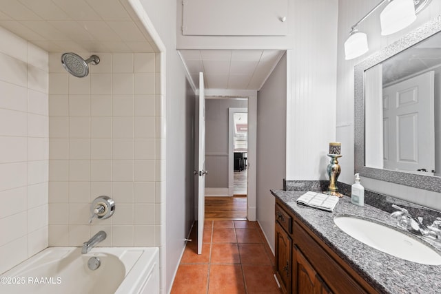 bathroom featuring tiled shower / bath, vanity, and tile patterned flooring