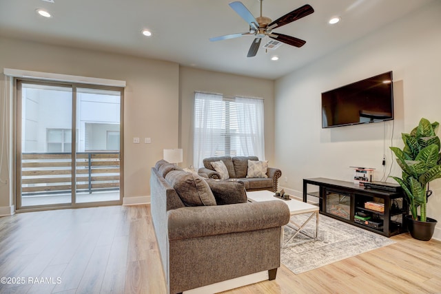 living room featuring light hardwood / wood-style flooring and ceiling fan