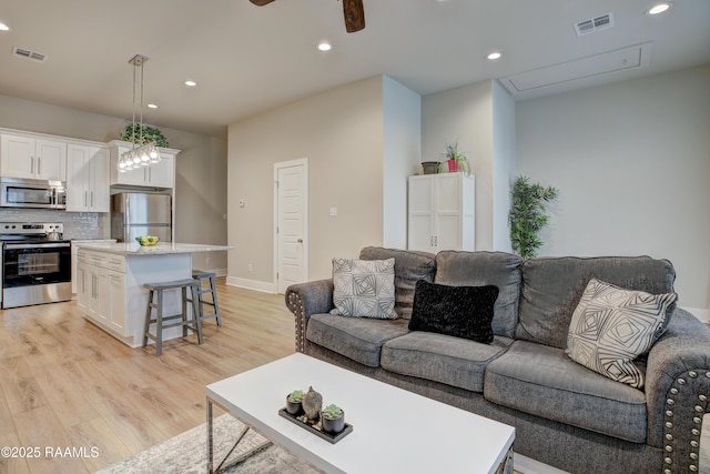 living room with light hardwood / wood-style flooring and ceiling fan