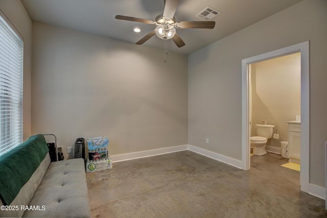 living area with ceiling fan and concrete flooring