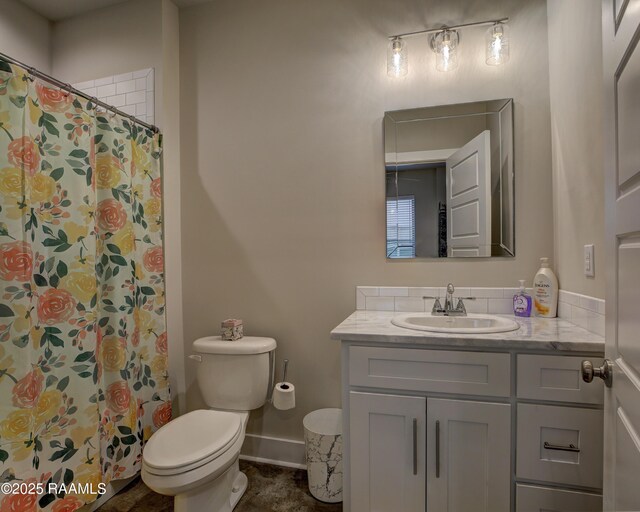 bathroom with walk in shower, vanity, and toilet