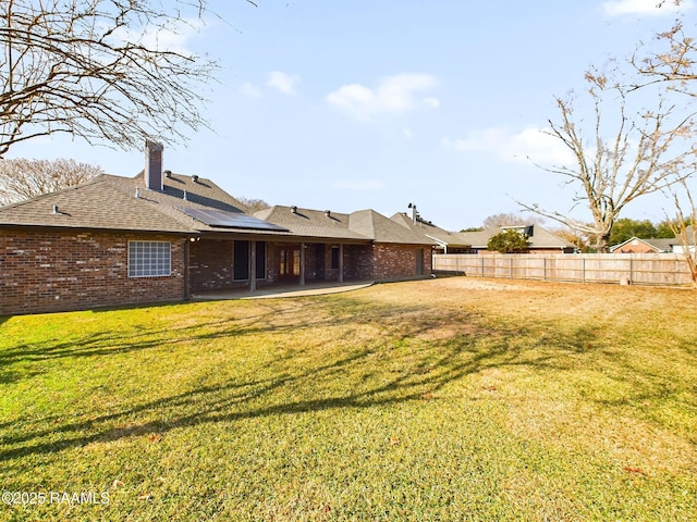 rear view of property with a yard and a patio area