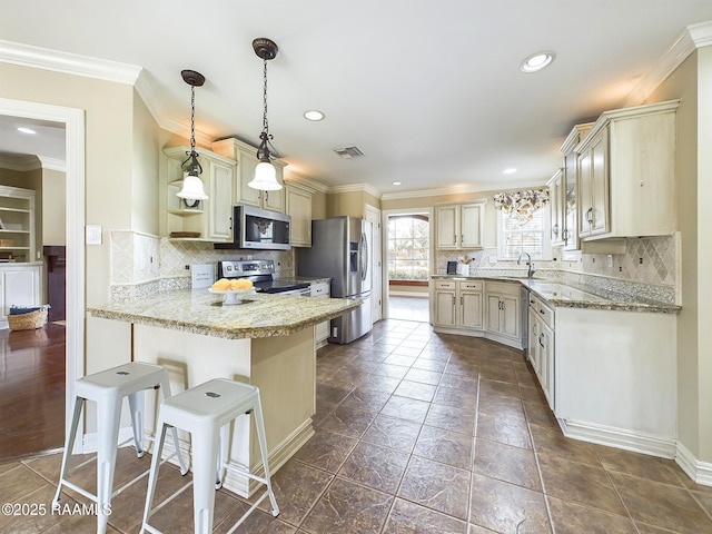 kitchen with pendant lighting, sink, a breakfast bar area, appliances with stainless steel finishes, and light stone counters