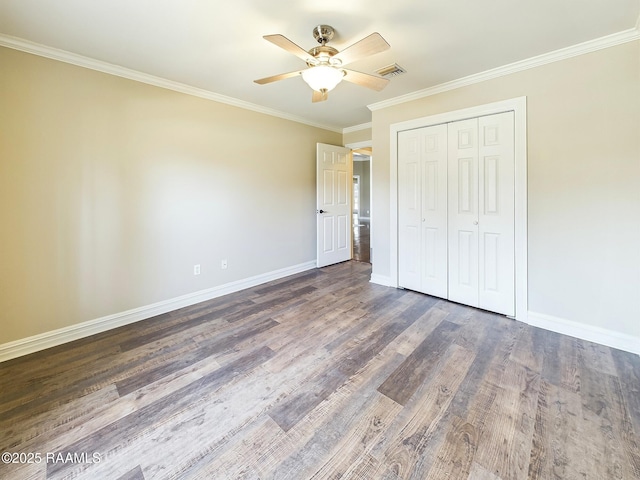 unfurnished bedroom with crown molding, ceiling fan, dark hardwood / wood-style flooring, and a closet