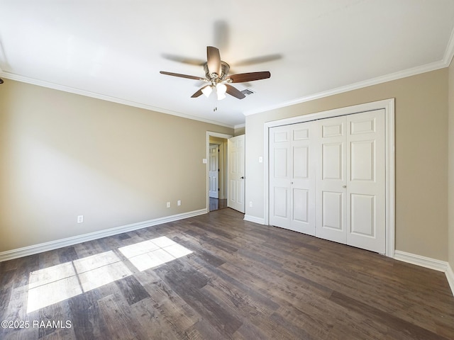 unfurnished bedroom with ornamental molding, dark hardwood / wood-style floors, ceiling fan, and a closet