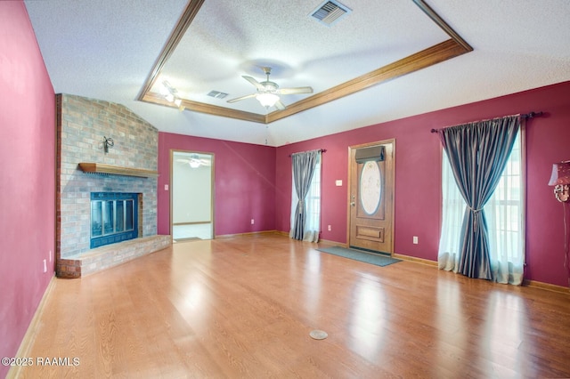 107 W Bayou Shr, Lafayette, LA 70508 - unfurnished living room with a raised ceiling, plenty of natural light, vaulted ceiling, and a brick fireplace