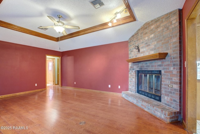107 W Bayou Shr, Lafayette, LA 70508 - unfurnished living room featuring a brick fireplace, ornamental molding, a textured ceiling, ceiling fan, and hardwood / wood-style flooring