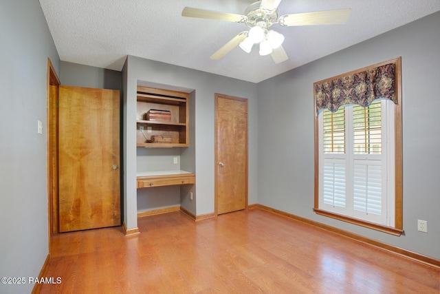 107 W Bayou Shr, Lafayette, LA 70508 - unfurnished bedroom with ceiling fan, built in desk, a textured ceiling, and light hardwood / wood-style floors