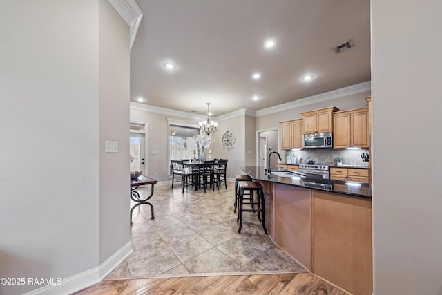 kitchen featuring hanging light fixtures, stainless steel appliances, an inviting chandelier, a breakfast bar area, and sink