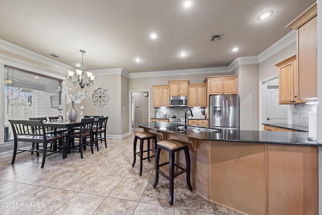 kitchen with appliances with stainless steel finishes, decorative light fixtures, crown molding, and sink