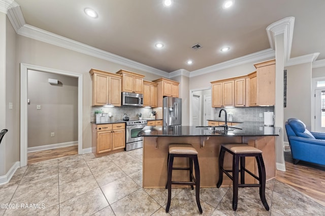 kitchen featuring kitchen peninsula, stainless steel appliances, a breakfast bar, crown molding, and sink