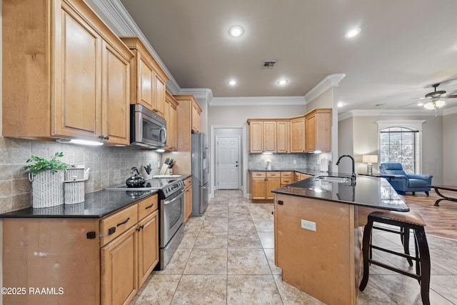 kitchen featuring a breakfast bar area, appliances with stainless steel finishes, kitchen peninsula, ornamental molding, and tasteful backsplash