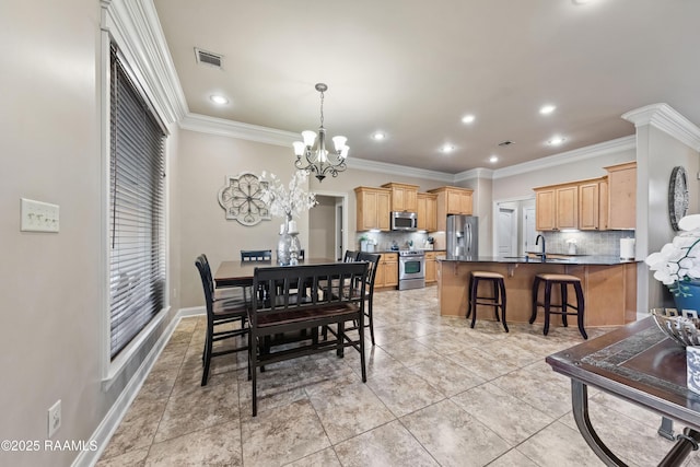 tiled dining space with sink, a chandelier, and crown molding