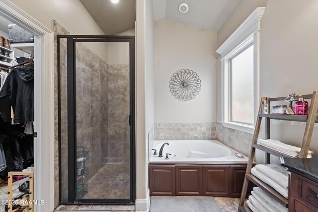 bathroom featuring vaulted ceiling and separate shower and tub