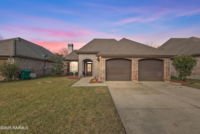 view of front of property featuring a lawn and a garage