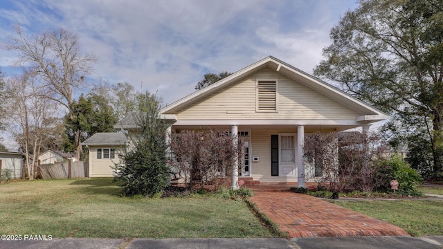 bungalow-style home with covered porch and a front yard