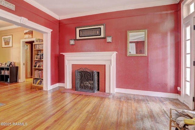 unfurnished living room with a fireplace, hardwood / wood-style floors, and ornamental molding