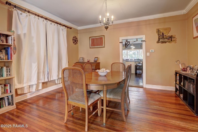 dining area with hardwood / wood-style floors, an inviting chandelier, and crown molding