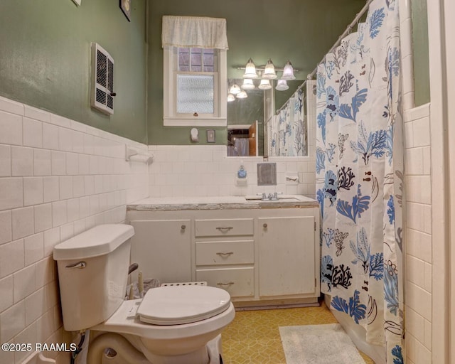 bathroom with vanity, curtained shower, toilet, and tile walls