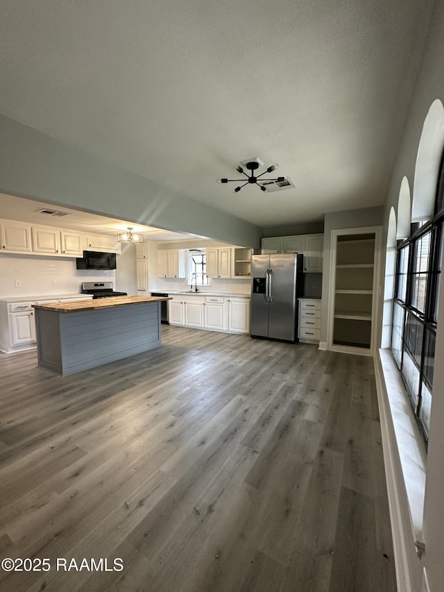 kitchen with sink, white cabinets, stainless steel appliances, and light hardwood / wood-style flooring