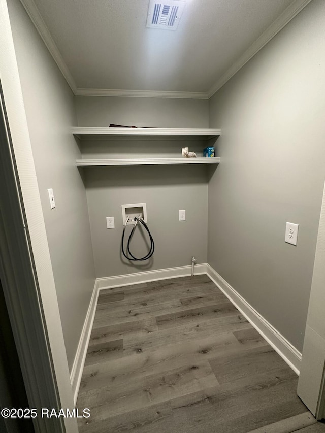 laundry room with dark hardwood / wood-style floors, ornamental molding, and hookup for a washing machine