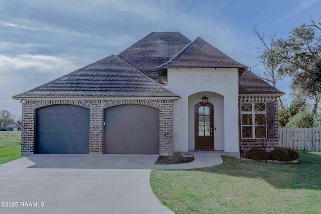 french country style house featuring a front yard and a garage