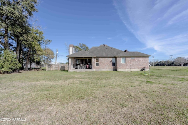 back of house with a patio area and a yard