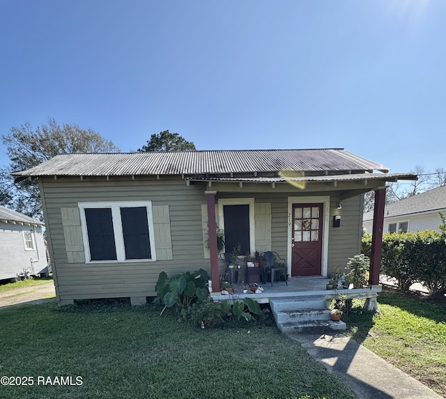 bungalow-style home featuring covered porch and a front yard