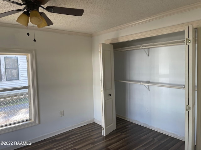 unfurnished bedroom with ceiling fan, dark hardwood / wood-style floors, crown molding, a textured ceiling, and a closet