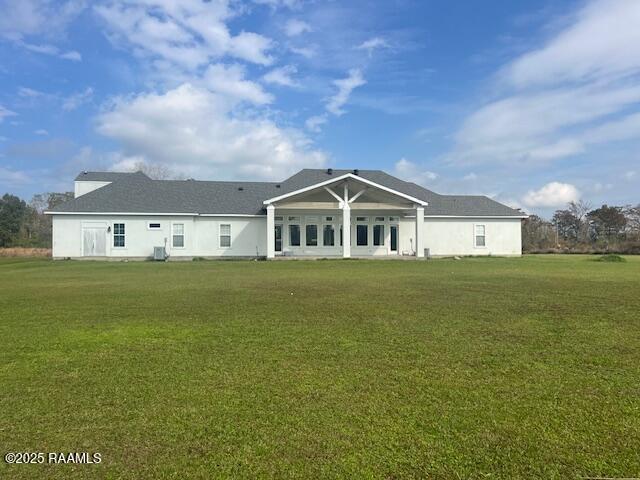 back of house featuring a lawn