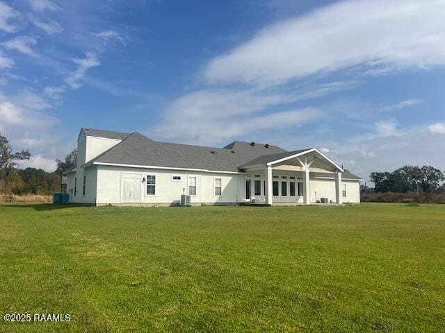 rear view of property featuring a lawn