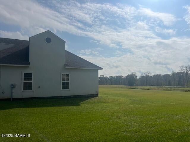 view of side of home with a yard