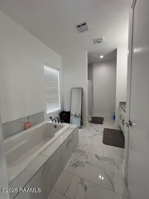 bathroom with vanity and shower with separate bathtub