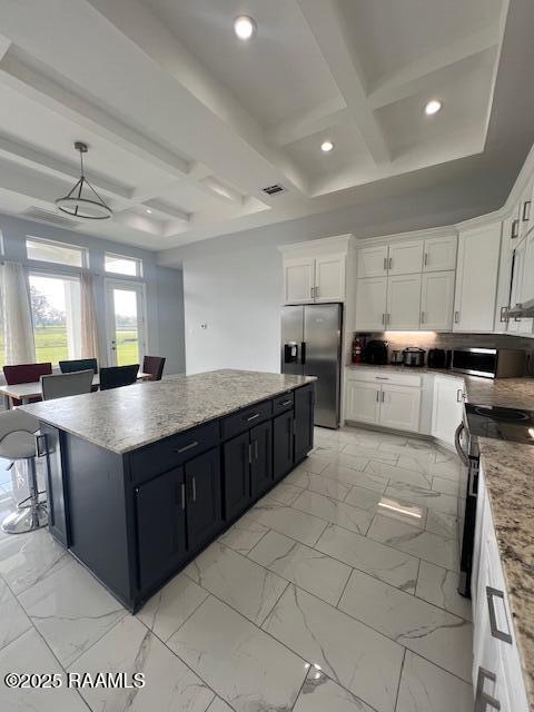 kitchen featuring white cabinets, appliances with stainless steel finishes, a center island, decorative light fixtures, and coffered ceiling