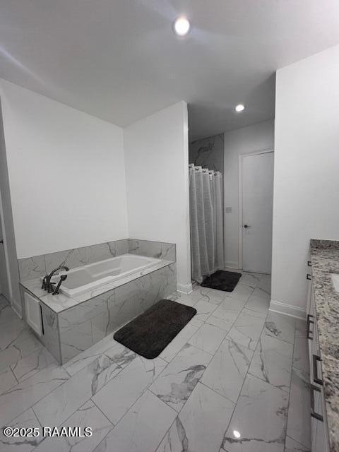 bathroom with a relaxing tiled tub and vanity