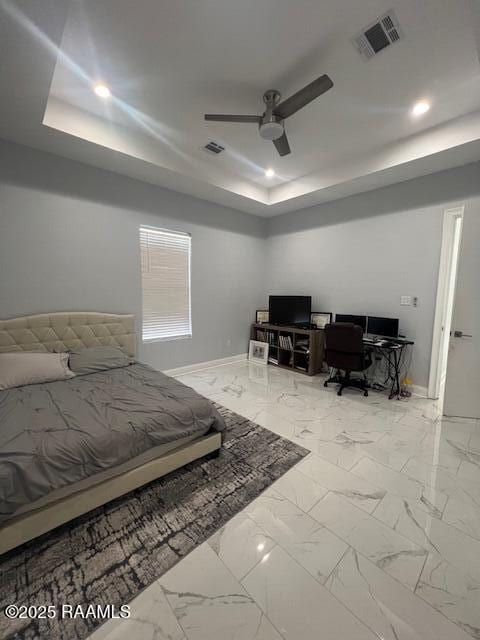 bedroom with ceiling fan and a tray ceiling