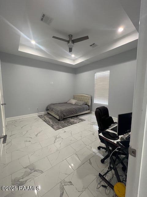 bedroom with a raised ceiling and ceiling fan