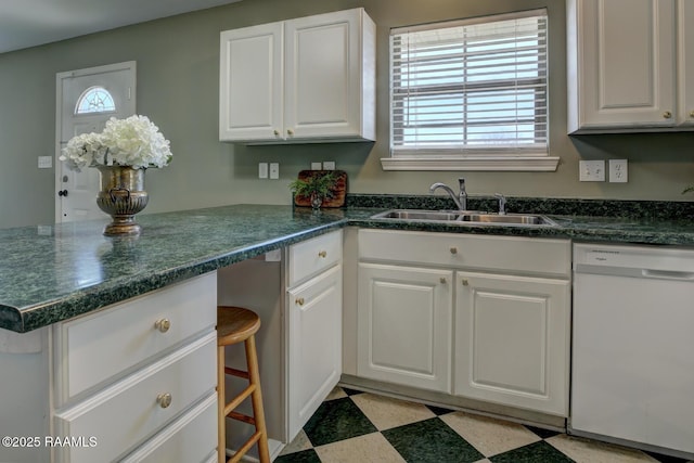 kitchen featuring white cabinets, dishwasher, sink, and a wealth of natural light