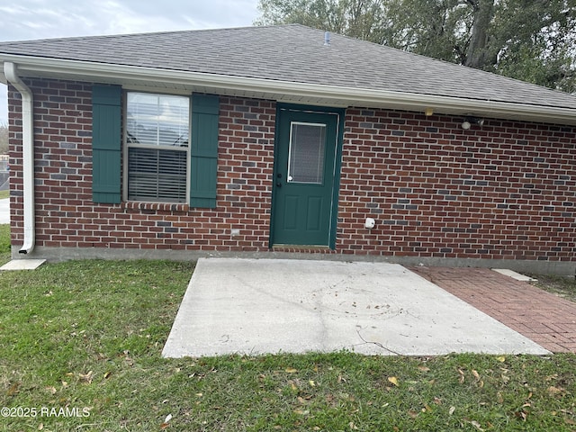 doorway to property with a yard and a patio