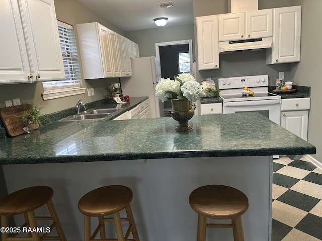 kitchen with a kitchen breakfast bar, white appliances, white cabinetry, and sink