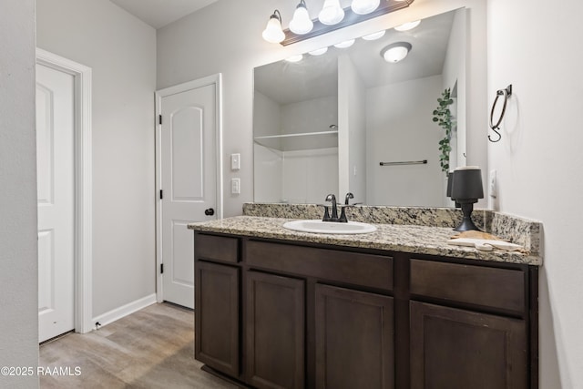 bathroom featuring wood-type flooring, vanity, and a shower