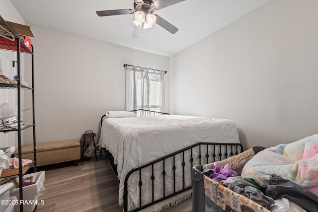 bedroom with ceiling fan, vaulted ceiling, and wood-type flooring