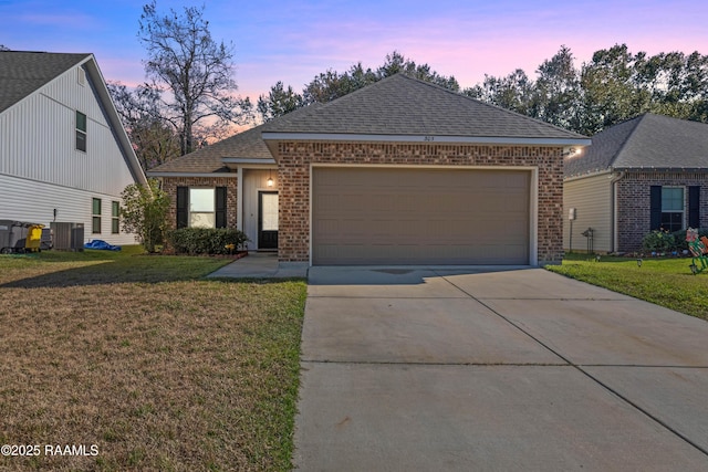 view of front of house with a lawn, central AC, and a garage