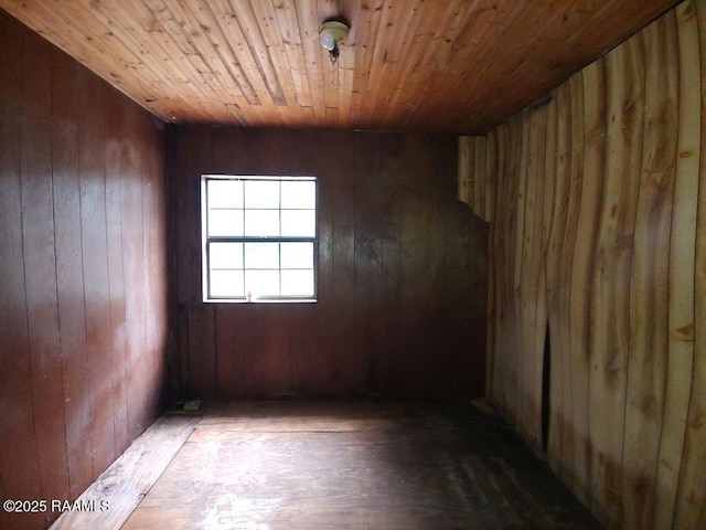 unfurnished room featuring hardwood / wood-style flooring, wooden walls, and wooden ceiling