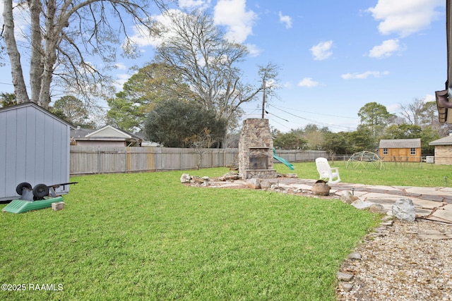 view of yard featuring an outdoor stone fireplace