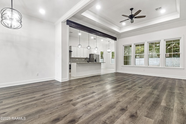 unfurnished living room with dark hardwood / wood-style flooring, ceiling fan, ornamental molding, and sink