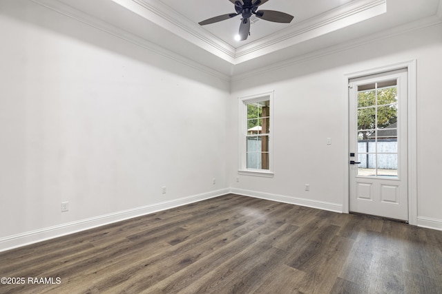 empty room featuring dark hardwood / wood-style flooring, a tray ceiling, and crown molding